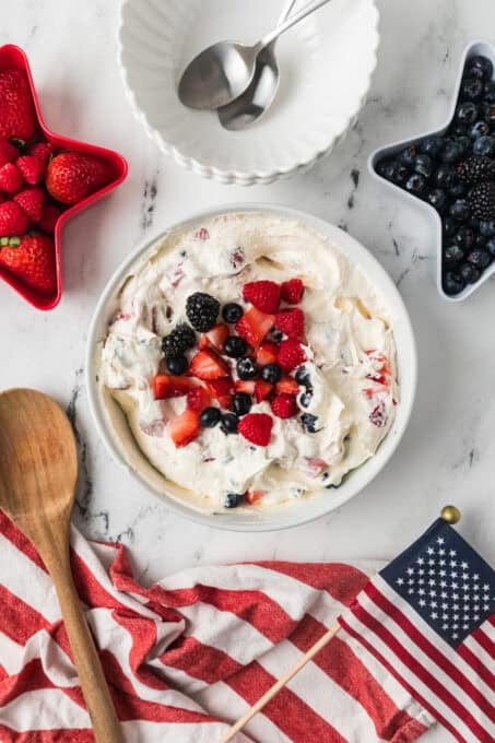 A bowl of a dessert salad made with fresh berries and a cheesecake mixture in a bowl.