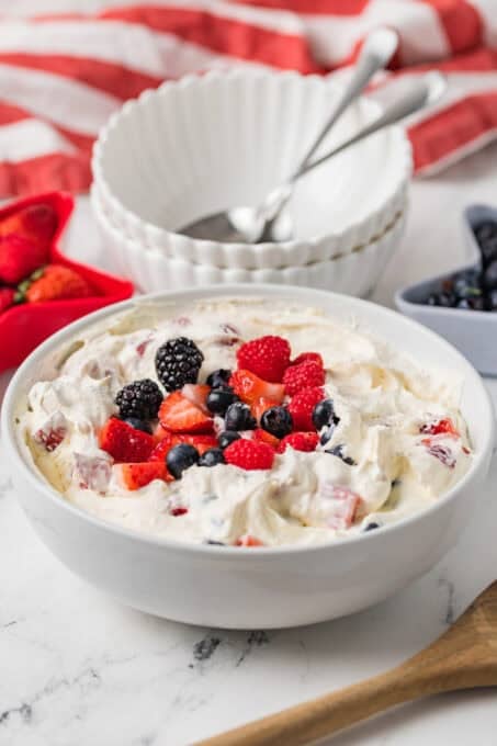 A bowl of fresh berries on top of a cheesecake dessert.