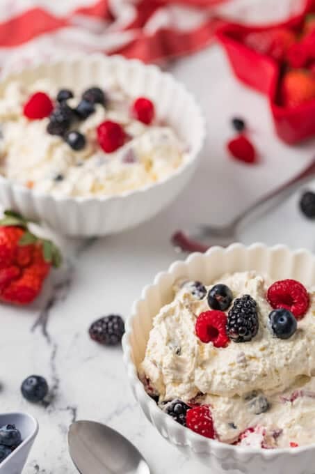 Two bowls of berries mixed with cheesecake.
