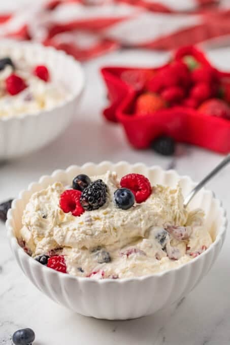 A no-bake cheesecake dessert with fresh berries in a bowl.