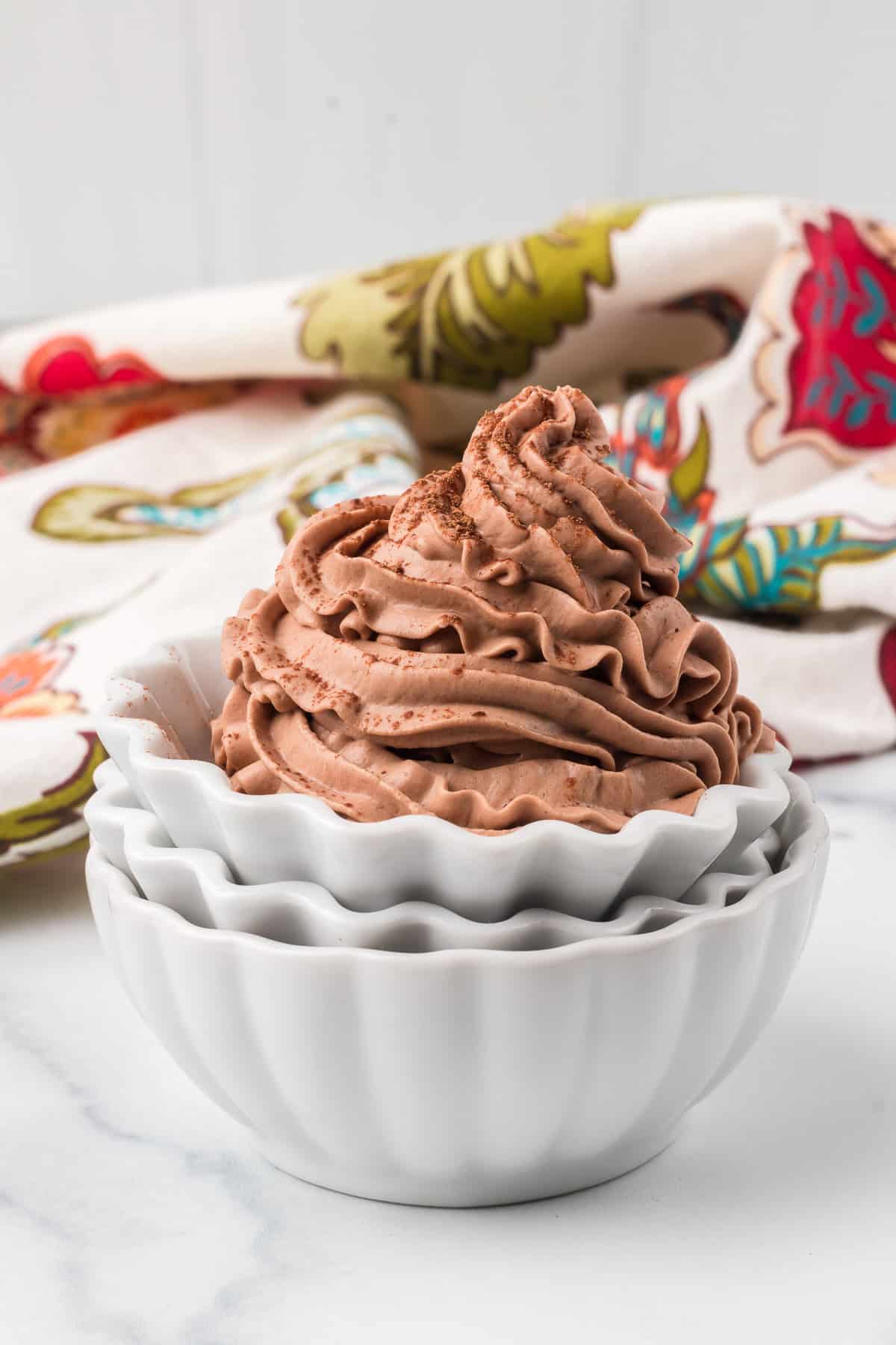 Piped chocolate cream for desserts in a stack of serving bowls.