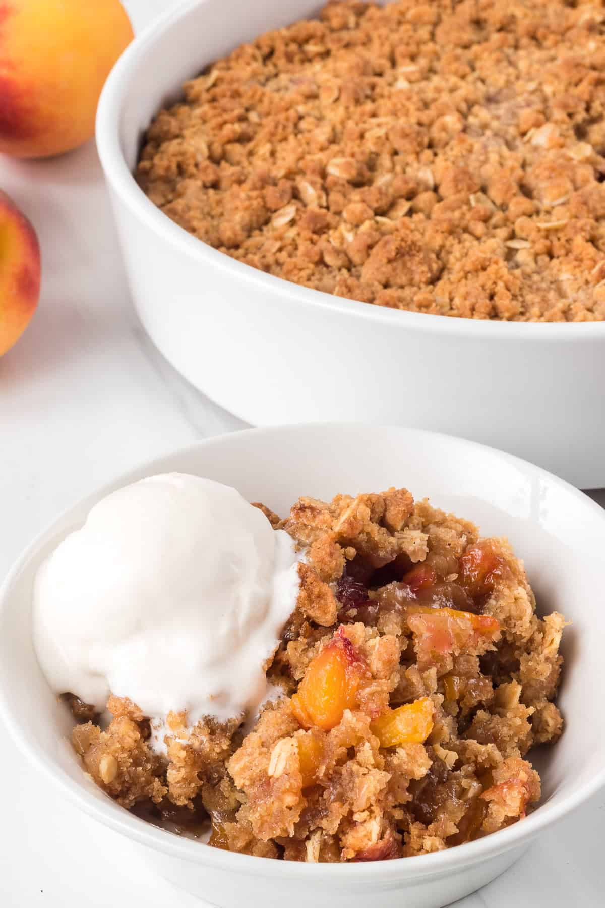 A scoop of vanilla ice cream on top of a crisp peach dessert.