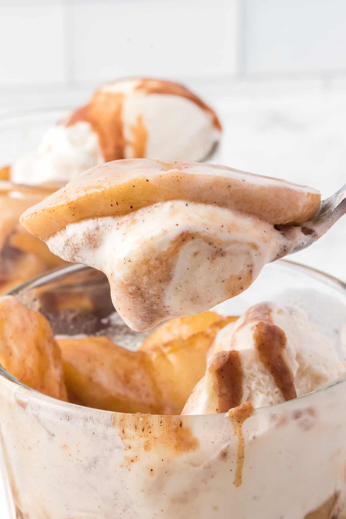 A spoonful of vanilla ice cream with spiced apple slices.